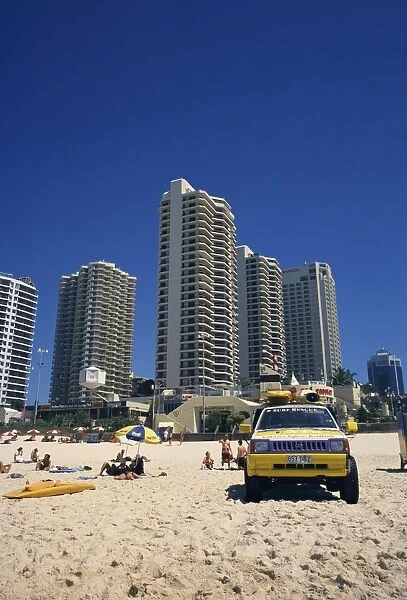 Lifeguards jeep on the beach at Surfers Paradise, with hotels and apartment blocks beyond