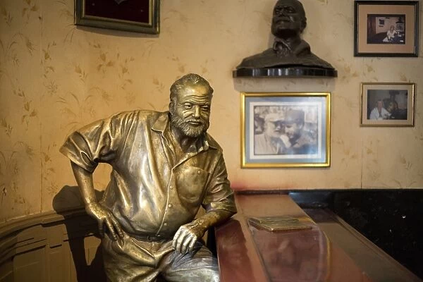 Lifesize bronze of the late author Ernest Hemingway at the bar of El Floridita, one of his favourite haunts, Havana, Cuba, West Indies, Central America