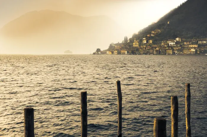 Framed Print : Light in the fog illuminates Peschiera Maraglio village, Monte Isola, Lake Iseo