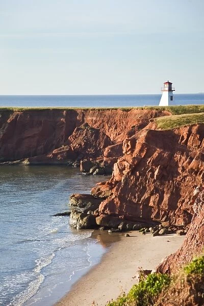 Lighthouse on a cliff overlooking a sandy beach on Havre-Aubert Island in the Iles de la Madeleine