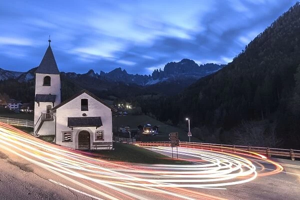 Lights of car trails around the Church of San Cipriano, Tires Valley, Dolomites, South Tyrol