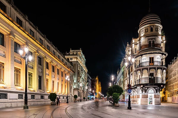 The lights of Sevilles buildings at night looking down the Avenida de la