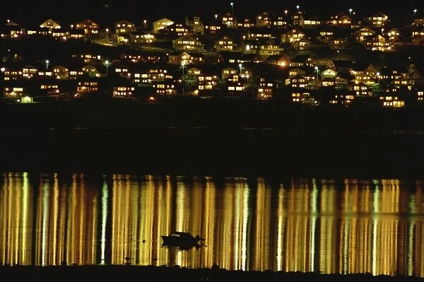 Lights of Tromso reflected off the sea at night