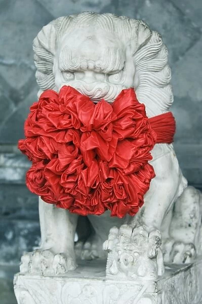 A lion statue decorated in red ribbon, Beijing, China, Asia