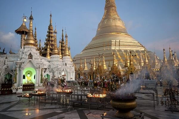 Lit candles placed by devotees at sunset at the Shwesagon Pagoda, a 2500 year old