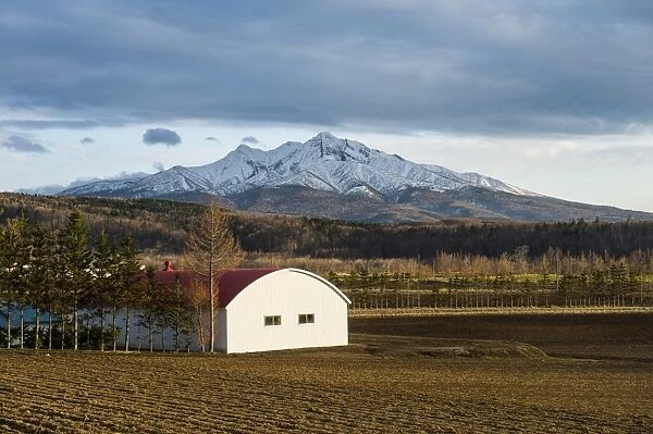 Little farm before a snow capped mountain near the Shiretoko National Park, Hokkaido