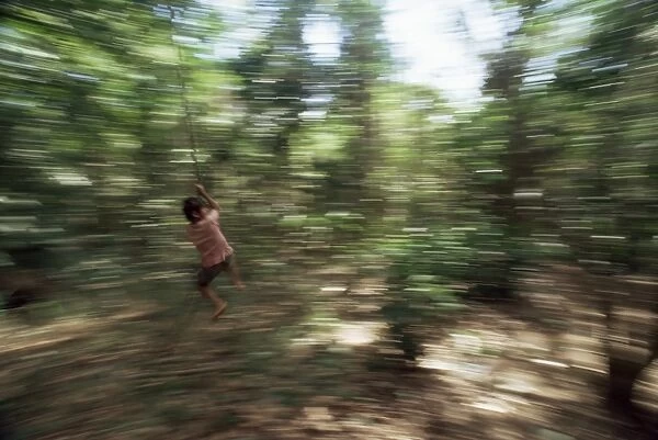 Local boy swings on vine, Corcovado National Park, Peninsula de Osa, Costa Rica