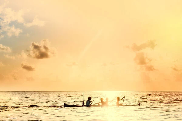 Local boys on a wooden canoe at sunset, Banda, Maluku, Spice Islands, Indonesia