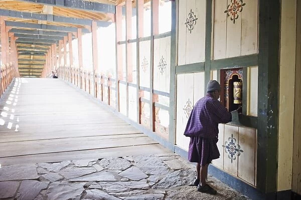Local man spinning a prayer wheel, Punakha Dzong dating from 1637, Punakha, Bhutan, Asia
