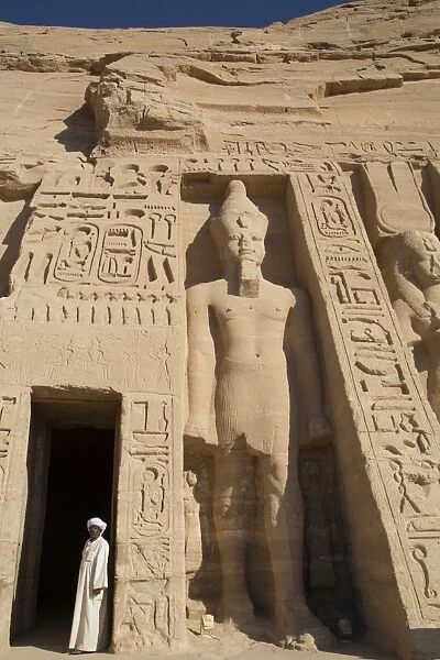 Local man at temple entrance, Ramses II statue on right, Hathor Temple of Queen Nefertari