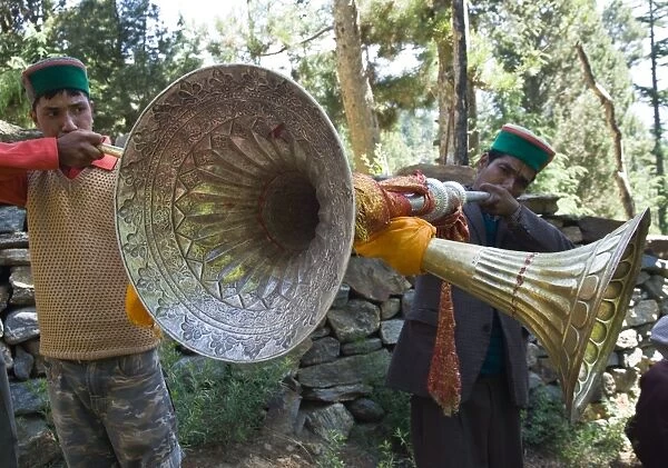 Two local men blowing large traditional wind instruments