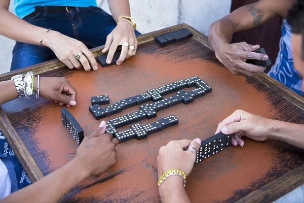 Local men playing dominos on a street in Cienfuegos, Cuba, West Indies, Central America