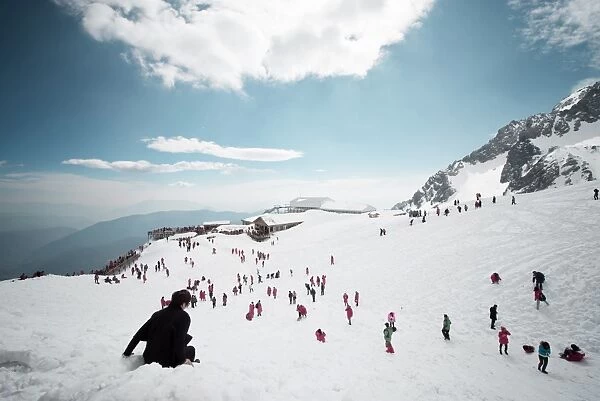 Mostly local tourists playing in the snow on top of Jade Dragon Snow Mountain near Lijiang, Yunnan province, China, Asia