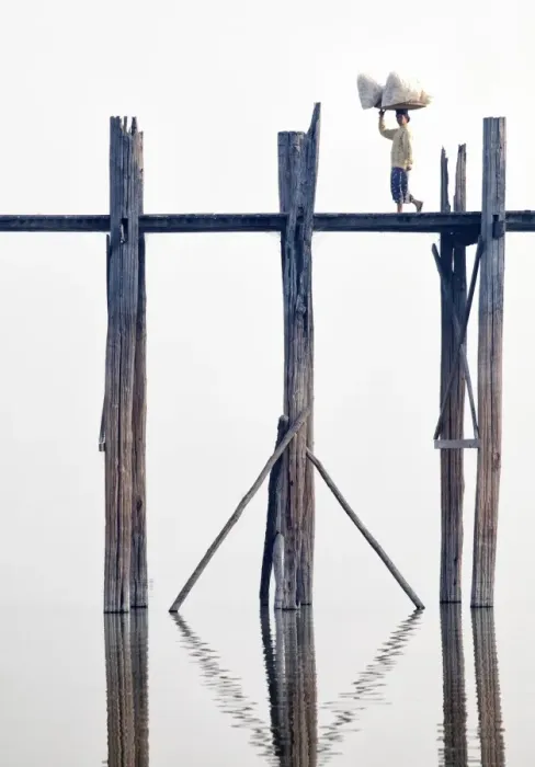 Framed Print : Local woman carrying goods on her head across U Bein Bridge, the worlds longest teak foot bridge spanning 1300 yards over Taungthaman Lake, Amarapura, near Mandalay, Myanmar (Burma), Asia