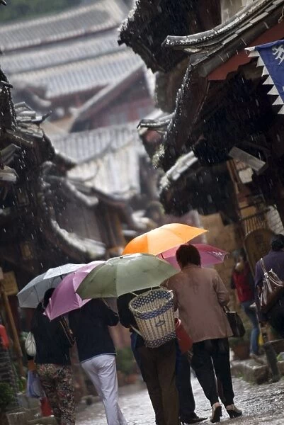 Locals with umbrellas in rain, Lijiang old town, UNESCO World Heritage Site