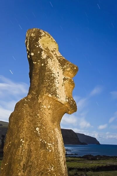 Lone monolithic giant stone Moai statue looking out to sea at Tongariki
