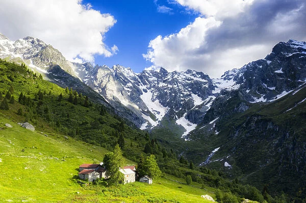 Lonely traditional group of huts in a wild alpine valley, Val d Arigna, Orobie, Valtellina, Lombardy, Italy. Europe