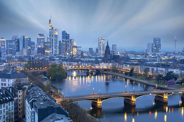 Long exposure of clouds at dusk over the illuminated city skyline and Ignatz Bubis bridge, Frankfurt am Main, Hesse, Germany Europe