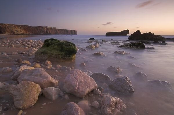 Long exposure of incoming tide on Tonal beach at sunset near Sagres