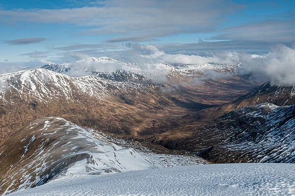 Looking down into Fionngleann in winter from Brothers Ridge in Kintail with the hills of