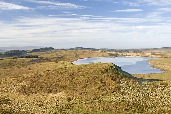 Looking west from Sewingshields Crag over Broomlee Lough with the line of Hadrians Wall following the crags on skyline, Hadrians Wall, UNESCO World Heritage Site, Northumbria, England, United