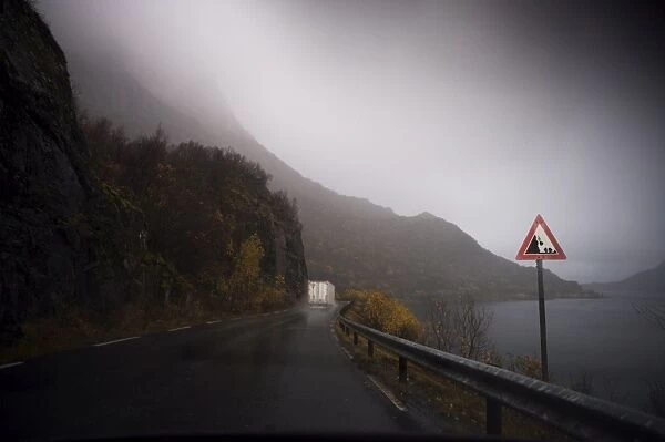 Lorry on wet road beside fjord, Norway, Scandinavia, Europe