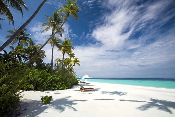 Lounge chairs under shade of umbrella on tropical beach, Maldives, Indian Ocean, Asia