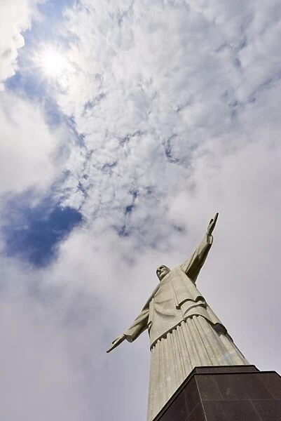 Low angle shot of the iconic statue of Christ the Redeemer on a cloudy day with sun