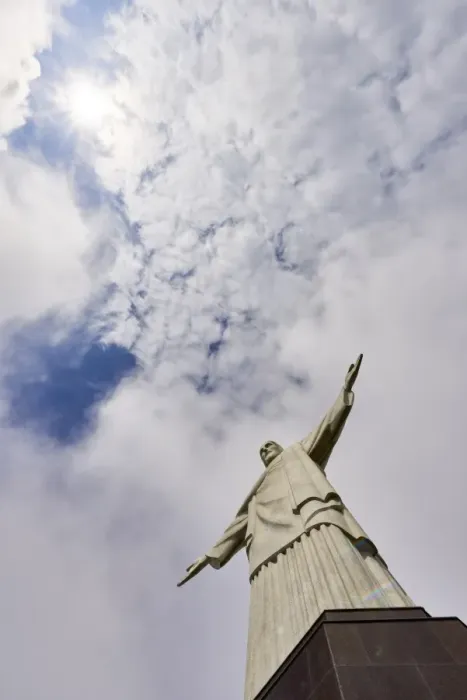 Framed Print : Low angle shot of the iconic statue of Christ the Redeemer on a cloudy day with sun