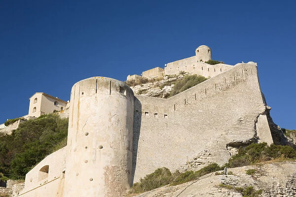 Low angle view of the massive stone walls and defensive towers of the citadel, Bonifacio, Corse-du-Sud, Corsica, France, Mediterranean, Europe