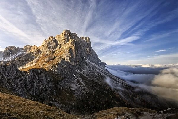 Low clouds and dawn lights on the peaks of Forcella De Furcia, Funes Valley, South Tyrol