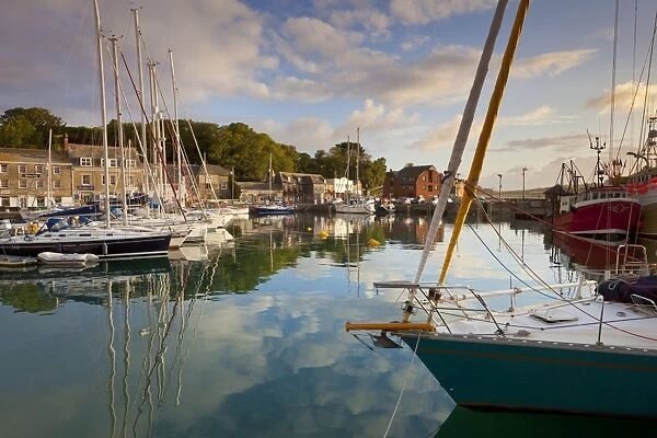 Low morning light and sailing yacht reflections at Padstow Harbour, Cornwall