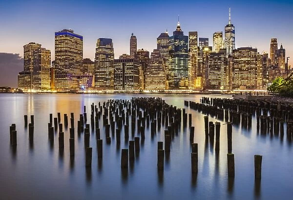 Lower Manhattan skyline, New York skyline, exposed wooden pier stumps, at night, East River