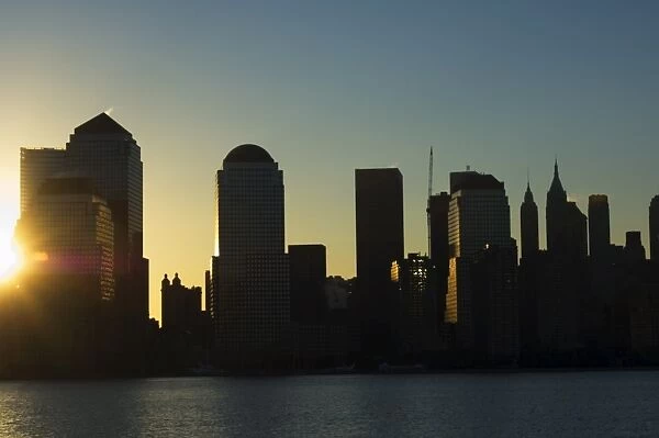 Lower Manhattan skyline at sunrise across the Hudson River