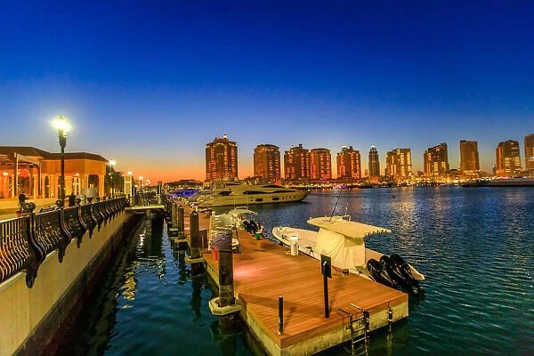 Luxurious yachts and boats docked at Porto Arabia Marina at night, The Pearl-Qatar