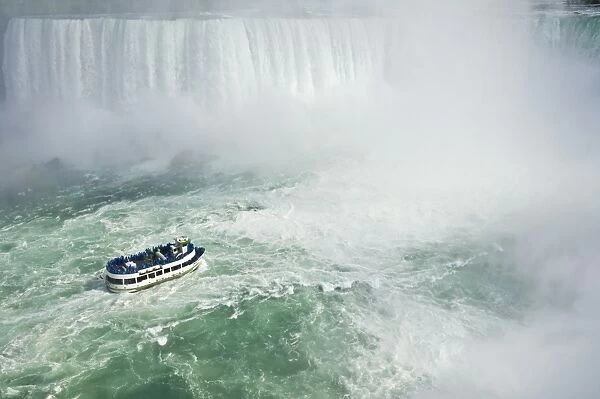 Maid of the Mist tour excursion boat under the Horseshoe Falls waterfall at Niagara Falls