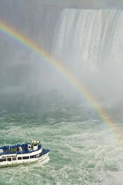 Maid of the Mist tour excursion boat under the Horseshoe Falls waterfall with rainbow at Niagara Falls, Ontario, Canada