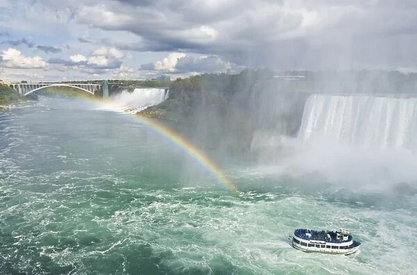 Maid of the Mist tour excursion boat under the Horseshoe Falls waterfall with rainbow at Niagara Falls, Ontario, Canada