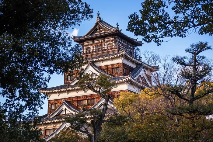 Framed Print : The Main Keep of Hiroshima Castle against a blue sky. Framed by Lush trees in the foreground. Hiroshima, Japan Framed Print : The Main Keep of Hiroshima Castle against a blue sky. Framed by Lush trees in the foreground. Hiroshima, Japan