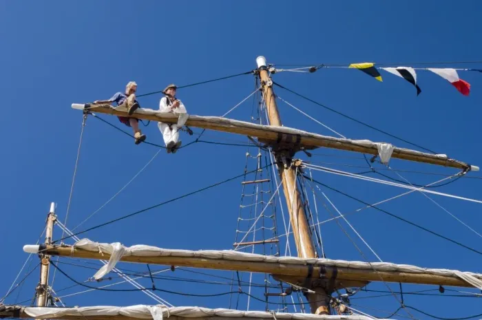 Framed Print : Detail of main mast of tall ship with two seamen on top yard securing sail Framed Print : Detail of main mast of tall ship with two seamen on top yard securing sail