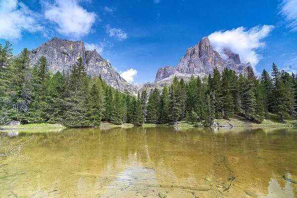 Majestic rock peak of Tofana di Rozes mirrored in the clear water of lake Bai De Dones, Dolomites, Lagazuoi Pass, Veneto, Italy, Europe