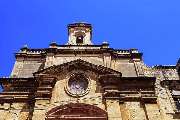 Malta Oratory of The Holy Cross exterior with limestone, Maltese cross and bell tower under a bright blue sky, old city of Birgu (Citta Vittoriosa), Malta, Mediterranean, Europe