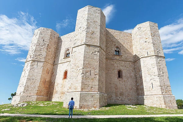 Man admires the octagonal castle of Castel del Monte in a clear sunny day, UNESCO World Heritage Site, Apulia, South of Italy, Italy, Europe