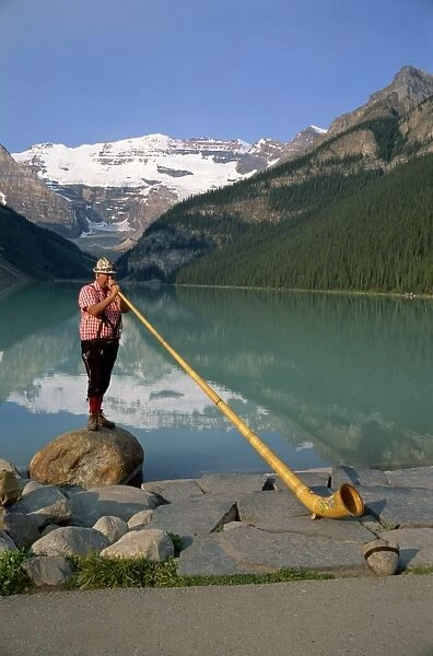 Man with an alpenhorn beside Lake Louise in the Banff National Park, Alberta