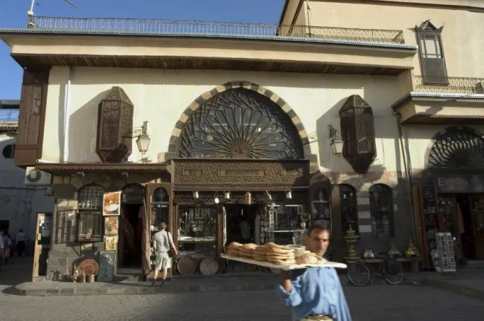 Framed Print : Man with bread walking past souvenir shop Framed Print : Man with bread walking past souvenir shop