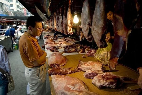 Man buying fresh meat at market, Xining, Qinghai, China, Asia