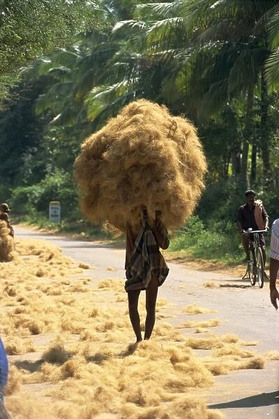 Man carrying coir fibre on his head