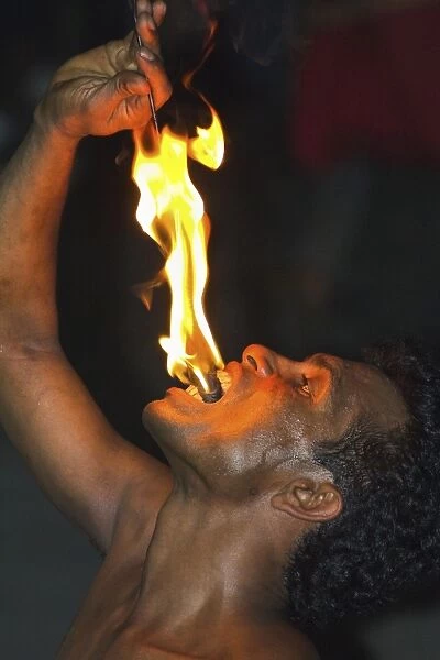 Man eating fire during the Fire Walking at a Kandyan dance show in the Kandyan Arts Association Hall, Kandy, Sri