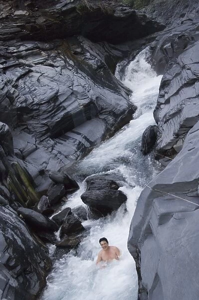 Man enjoying natural hot river water of Tona hotspring bath resort