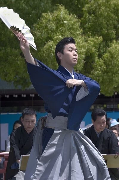 Man with fan performing classical Japanese dance called hobu at Meiji Jingu shrine